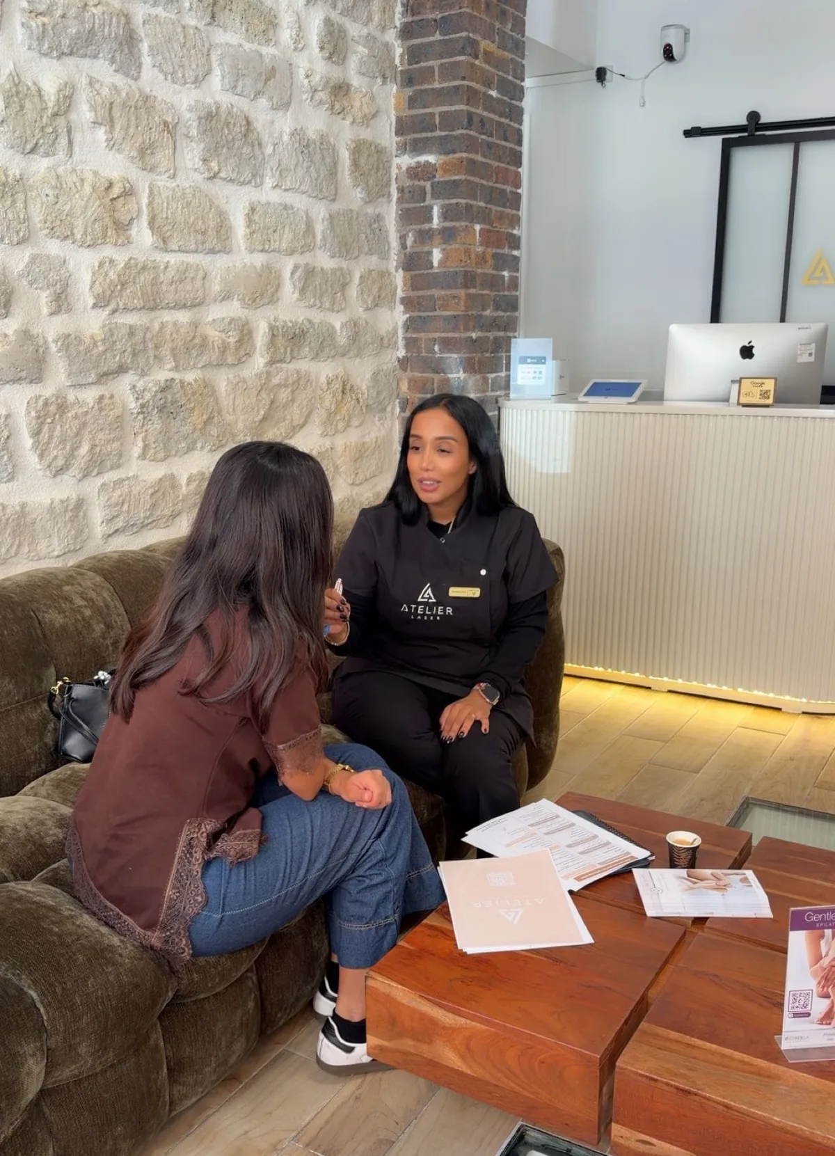 Le bilan offert : une infirmière de l'Atelier Laser 17 explique le déroulé des séances à une cliente, dans le salon d'accueil aux murs de pierre